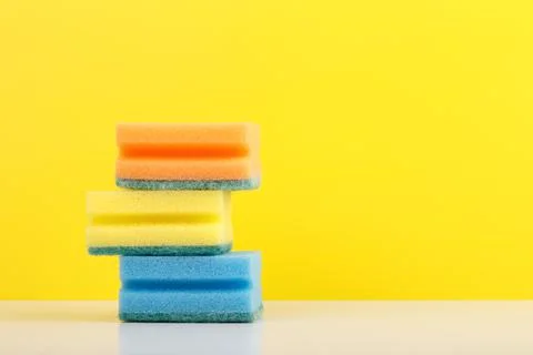 Stack of colorful sponges for washing dishes or cleaning on white table against Stock Photos