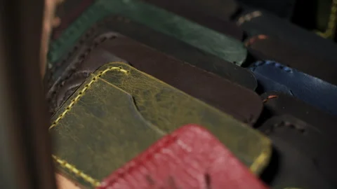 Stack of colorful stitched leather wallets Stock Footage 320699612