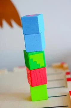 Stack of colorful toy cubes on a blurred background Stock Photos