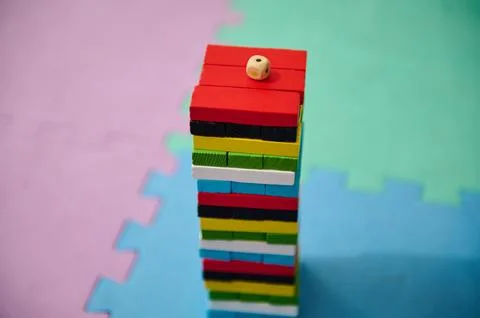 Stack of colorful wooden blocks with dice on top on foam mat Foto stock