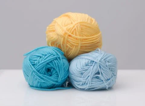 Stack of colorful yellow and blue yarn balls for knitting and crochet hobby 库存照片