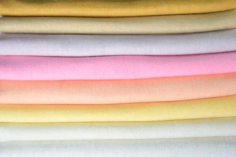 Stack of colourful cotton clothes, pile of clothing on white background Stock Photos