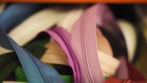 Stack of colourful fabric zippers on the shelf in workshop, zippers of different Stock Footage 246979378