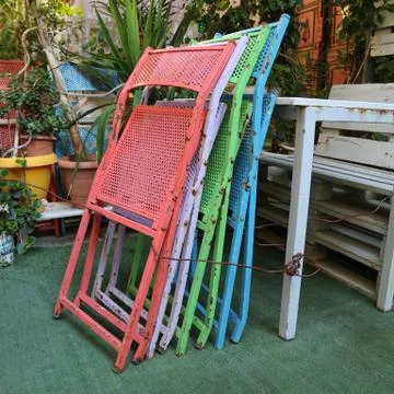 A stack of colourful metal chairs Stock Photos