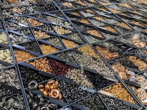A stack of compartmentalized containers filled with assorted round beads or.. Stockfoto's