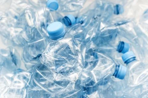 Stack of compressed plastic bottles with blue caps Stock Photos