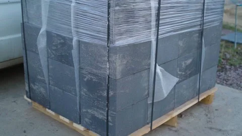 Stack of concrete blocks wrapped in plastic film on wooden pallet Stock-Footage 337309763