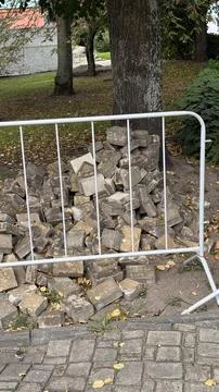 Stack of concrete bricks behind a metal fence, outdoor construction site ba.. Stock Photos
