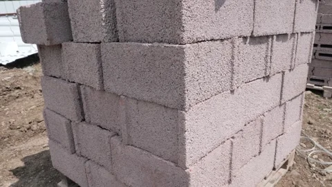 Stack of concrete building blocks at a construction site during daylight Vidéo 284980147