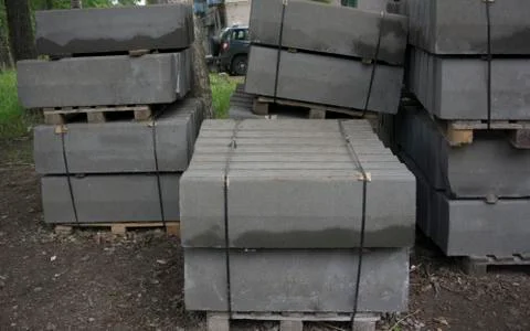 Stack of concrete curbstone. Construction process Stock Photos