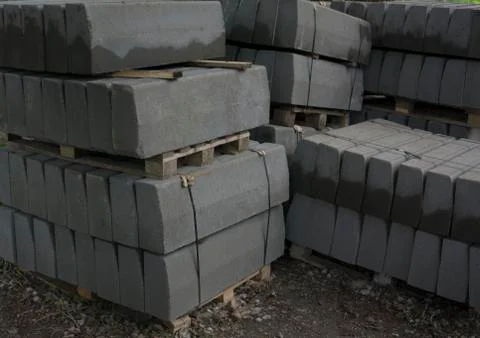 Stack of concrete curbstone. Construction process Stock Photos