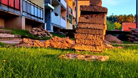 Stack Of Concrete Slabs On Grass Near Apartment Building Under Warm Evening Stock Footage 320376819