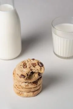 Stack of cookies between a blurred bottle and glass of milk 스톡 사진