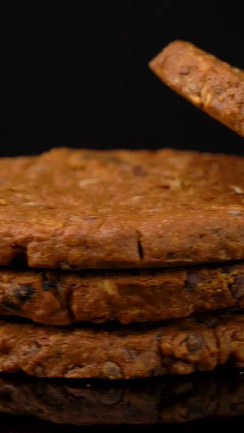 Stack of Cookies With Seeds Rotating Under Studio Lighting on Dark Background Stock Footage 330517448