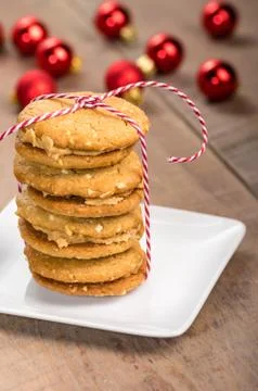 Stack of cookies on white plate with red balls Stock Photos
