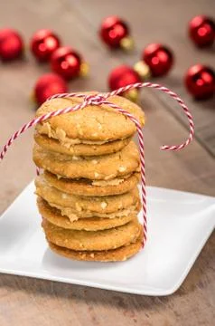 Stack of cookies on white plate with red balls Foto stock