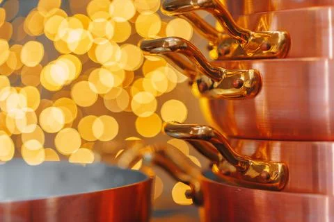 Stack of copper cooking pans on wooden table close up Stock Photos