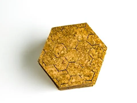 Stack of cork hot pads in hexagon shape isolated on white background. Top vie Stock Photos