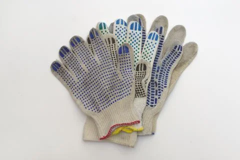 Stack of cotton gloves with multicolored rubber dots, elastic cuffs, border.. Stock Photos