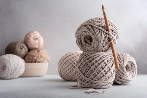Stack of cotton threads pastel color skeins and wooden hook for craft and han Stock Photos