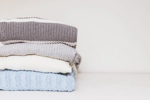 Stack of cozy comfortable homely clean washed knitted sweaters in pastel colo Stock Photos