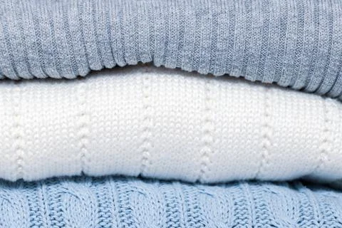 Stack of cozy comfortable homely clean washed knitted sweaters in pastel colo Stock Photos