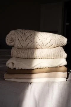 Stack of Cozy Knit Sweaters in Natural Light Stock Photos