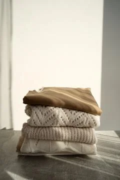 Stack of Cozy Knit Sweaters in Natural Light Stock Photos