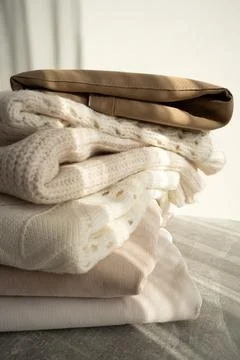 Stack of Cozy Knit Sweaters in Natural Light Stock Photos