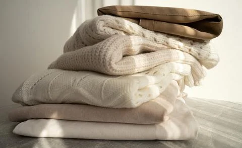 Stack of Cozy Knit Sweaters in Natural Light Stock Photos