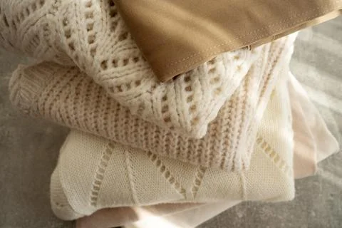 Stack of Cozy Knit Sweaters in Natural Light Stock Photos