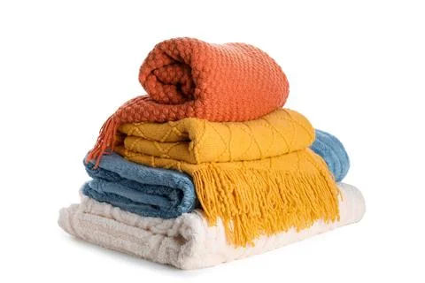 Stack of cozy knitted and fleece blankets in warm autumn colors for home comf Stock Photos