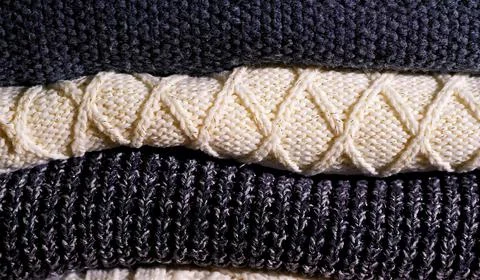 Stack of cozy knitted gray sweaters . Retro style. Warm concept . Stock Photos