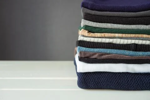 Stack of cozy knitted sweaters on white background. Stock Photos