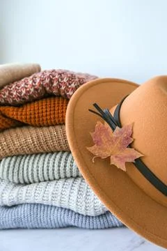 Stack of cozy knitted warm sweater with Autumn fall maple leaf and beige stylish Stock Photos