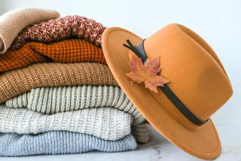 Stack of cozy knitted warm sweater with Autumn fall maple leaf and beige stylish Stock Photos