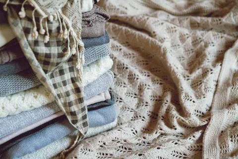 A stack of cozy warm winter clothes lies on the bed Stock Photos