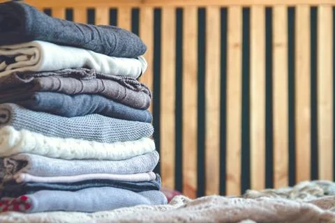 A stack of cozy warm winter clothes lies on the bed Stock-Fotos