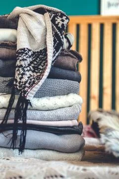 A stack of cozy warm winter clothes lies on the bed Stock Photos