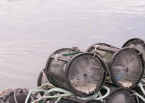 Stack of crab and lobster pots on a dock near the water Stock Photos