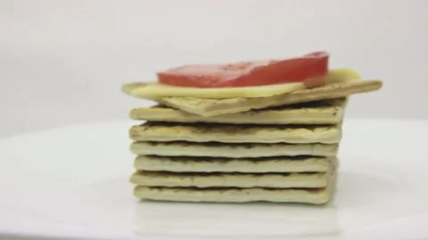 Stack of crackers, toast with cheese and tomato rotates on a white background Stock Footage 131215229