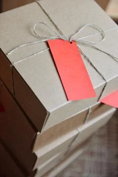 Stack of craft boxes with gifts tied with a cord with tag Stock Photos