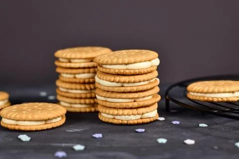 Stack of cream filled sandwich double cookies on dark background Foto stock