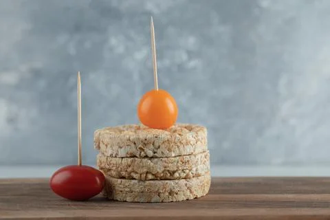 Stack of crispbread and cherry tomatoes on wooden board Stock Photos