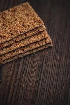 Stack of crispbread crackers on a dark wooden table, showcasing healthy sna.. Stock Photos