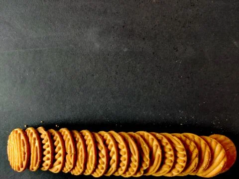 Stack of crispy cookies or biscuits. Copy space. Black background. Stock Photos