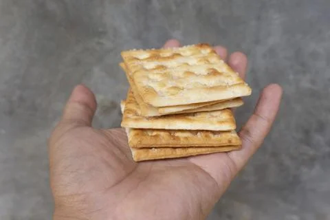 Stack of Crispy Crackers on Hand Stock Photos