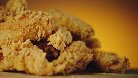 Stack of crispy fried chicken parts placed on wooden board. Slow motion video Stock Footage 149737386