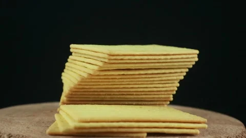 Stack of crispy salted crackers on black background. Rotating display 스톡 동영상 293777139