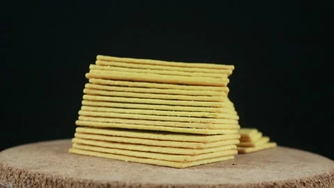 Stack of crispy salted crackers on black background. Rotating display 스톡 동영상 293777188